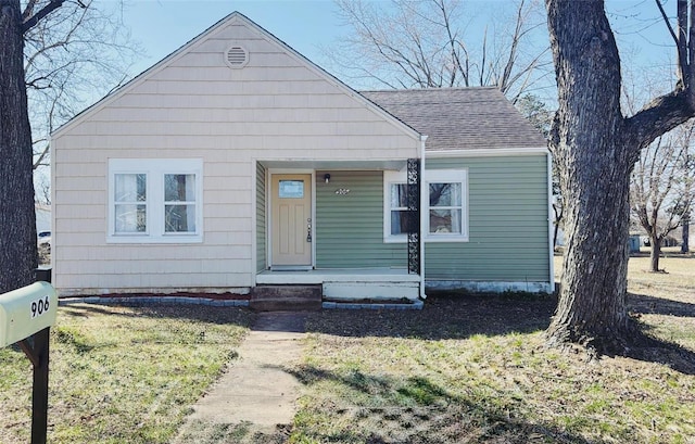 bungalow-style home with covered porch and roof with shingles