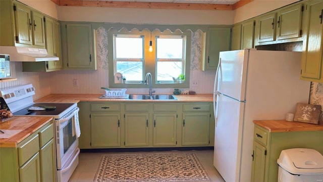 kitchen with a sink, white appliances, green cabinets, and exhaust hood