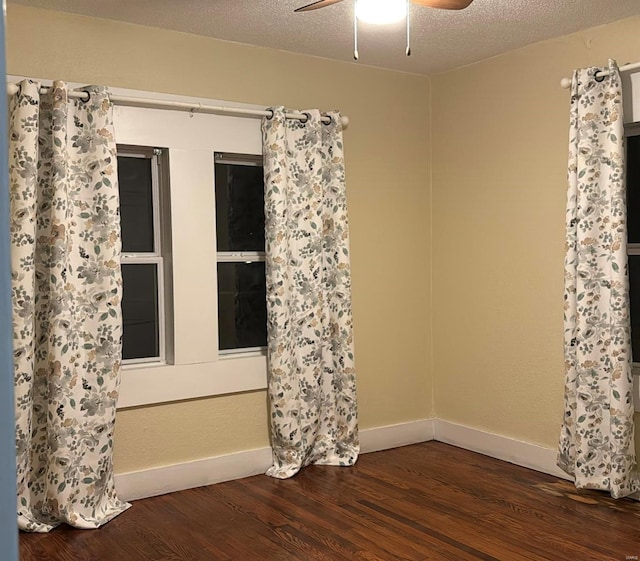 unfurnished room featuring baseboards, a textured ceiling, wood finished floors, and a ceiling fan