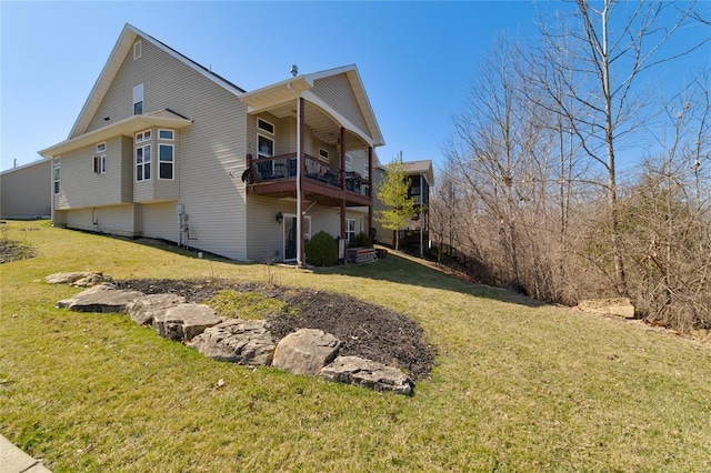 view of side of home featuring a balcony and a yard