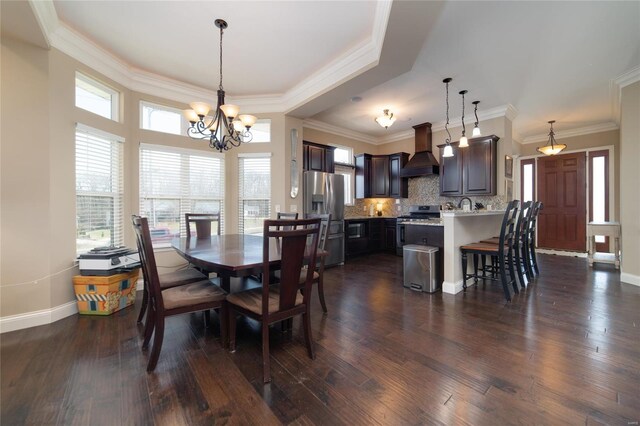 dining room featuring dark wood finished floors, a notable chandelier, baseboards, and ornamental molding