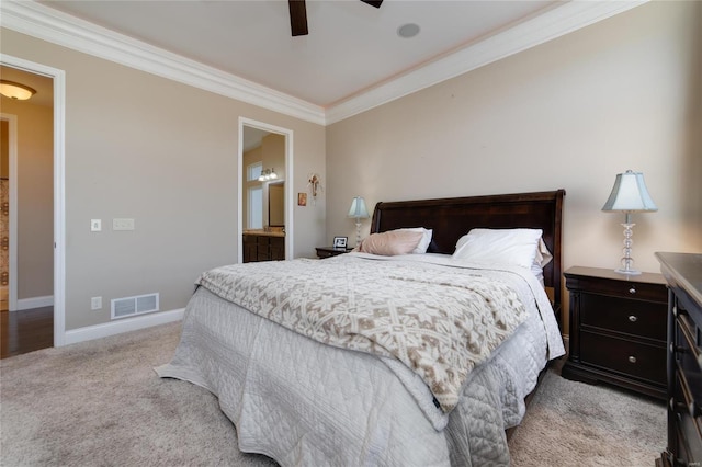 carpeted bedroom with visible vents, ensuite bathroom, crown molding, baseboards, and ceiling fan