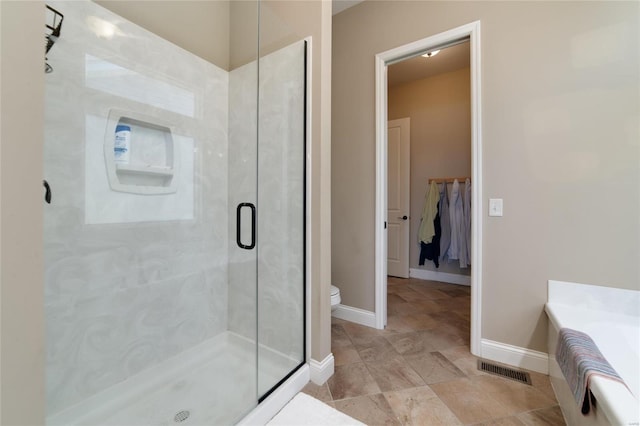 full bath featuring visible vents, toilet, a stall shower, baseboards, and a bath