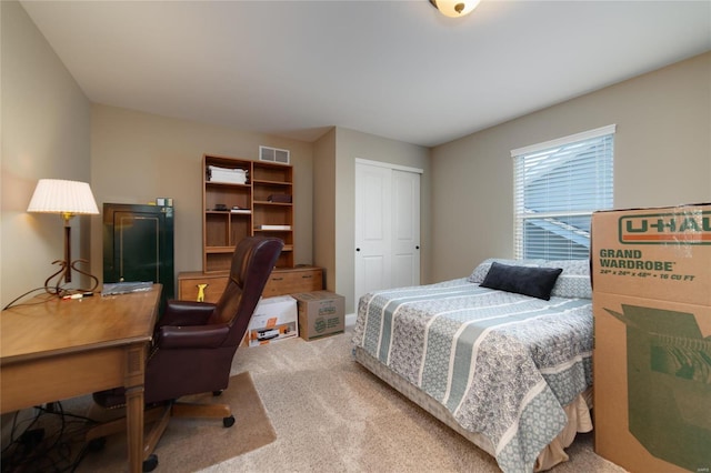 bedroom with a closet, visible vents, and carpet