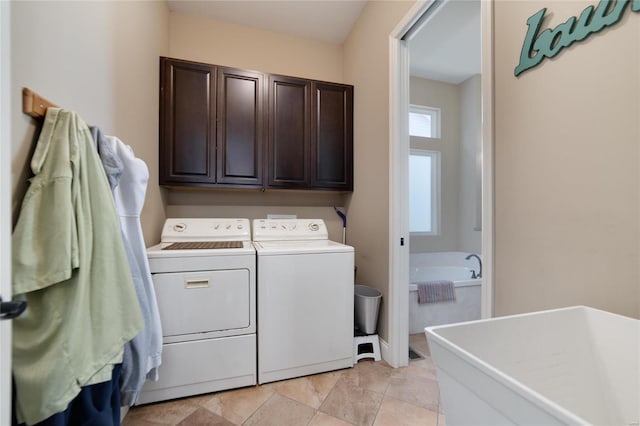 laundry room featuring washing machine and clothes dryer and cabinet space