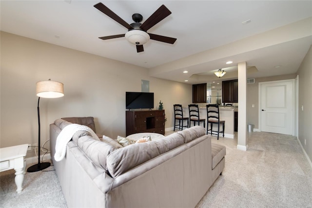 living area with visible vents, baseboards, ceiling fan, light colored carpet, and recessed lighting