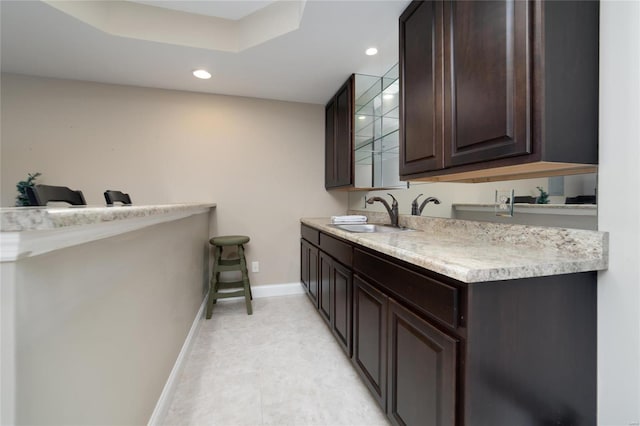 bathroom featuring a sink, baseboards, recessed lighting, and double vanity