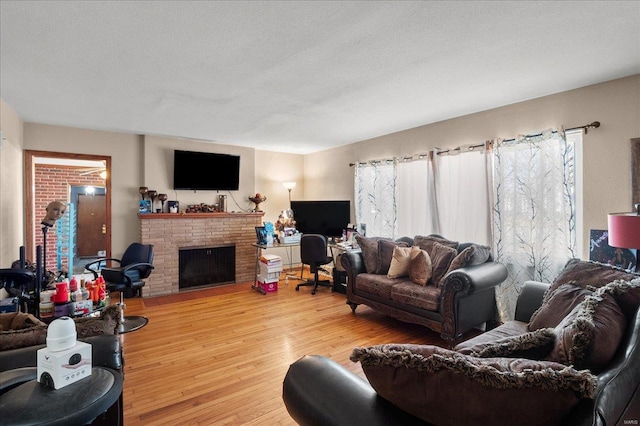 living room with a fireplace, wood finished floors, and a textured ceiling