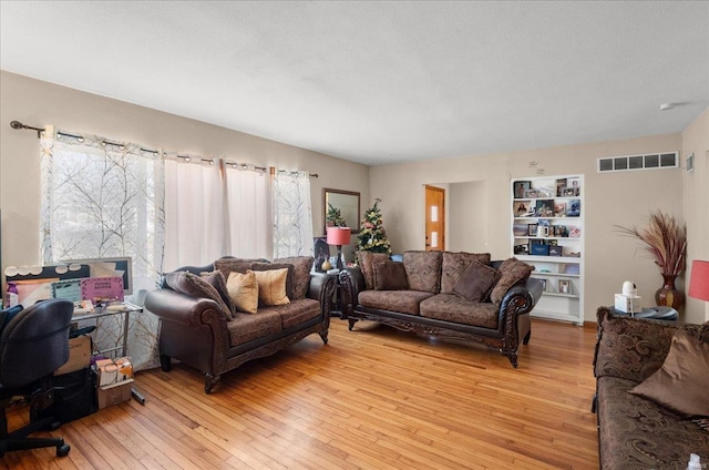 living room featuring light wood-style flooring and visible vents