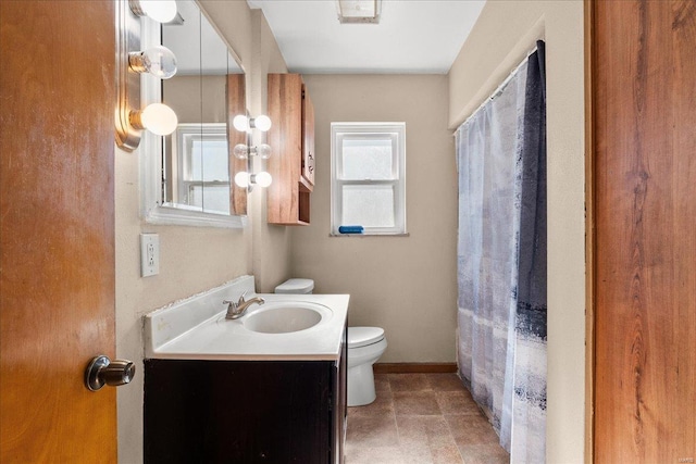 bathroom with vanity, a shower with shower curtain, toilet, and baseboards