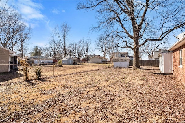 view of yard featuring an outbuilding, fence private yard, and a storage unit