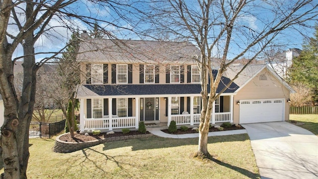 colonial-style house with a front lawn, fence, concrete driveway, covered porch, and an attached garage