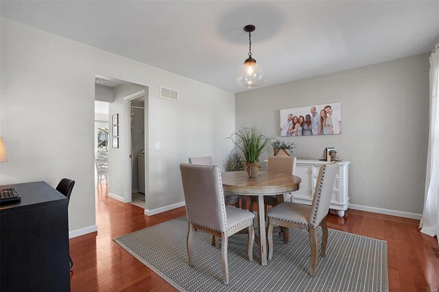 dining space featuring visible vents, baseboards, and wood finished floors