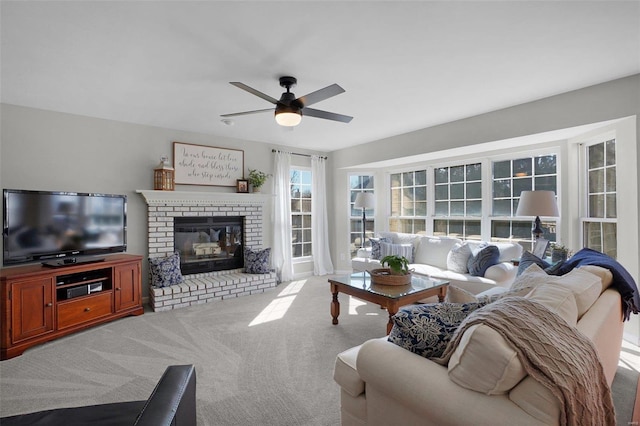 carpeted living area featuring a brick fireplace and a ceiling fan