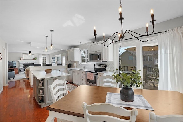 dining area with a ceiling fan, wood finished floors, and a fireplace