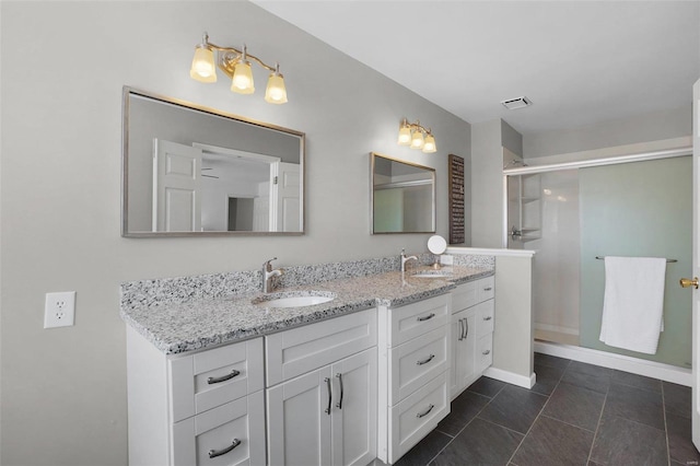 bathroom with a sink, a stall shower, double vanity, and tile patterned floors