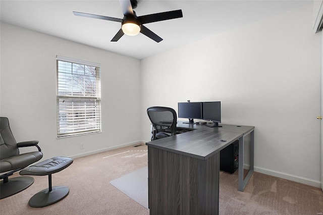 office featuring baseboards, light colored carpet, and a ceiling fan