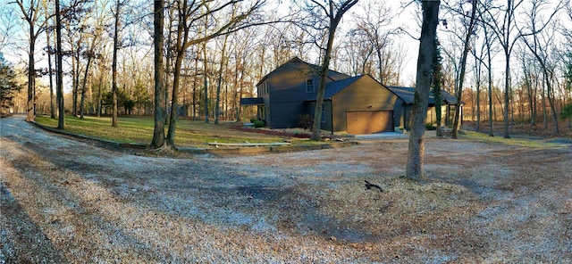 view of front of property with dirt driveway and an attached garage