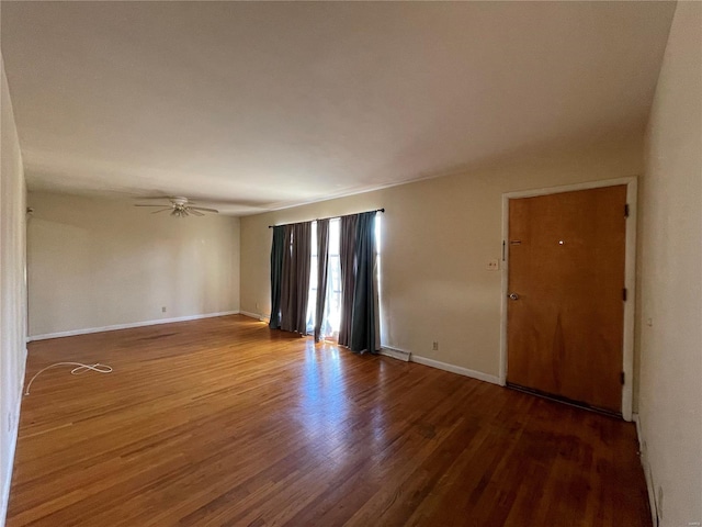 unfurnished room featuring wood finished floors, baseboards, and ceiling fan