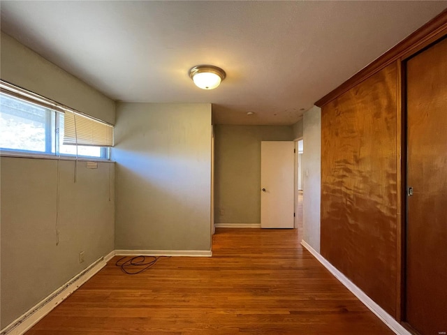 unfurnished room with wood finished floors and baseboards