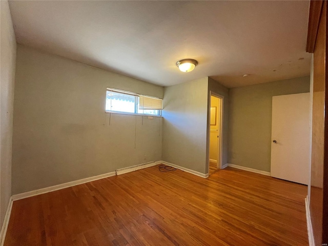 empty room featuring wood finished floors and baseboards