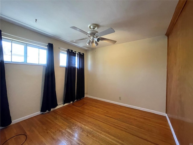 unfurnished room with ceiling fan, baseboards, and wood finished floors