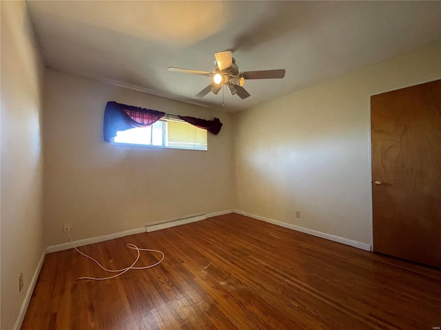 spare room with baseboards, baseboard heating, wood finished floors, and a ceiling fan