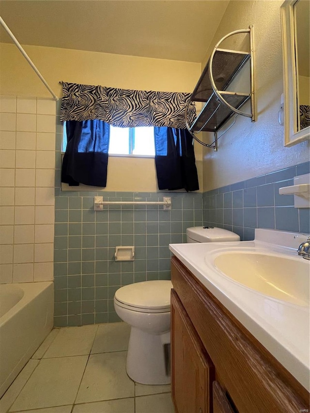 full bathroom featuring washtub / shower combination, tile patterned flooring, wainscoting, tile walls, and toilet