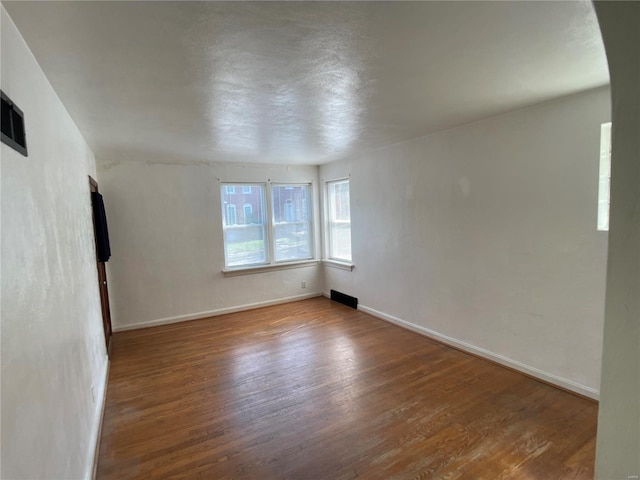 unfurnished room with baseboards and wood finished floors