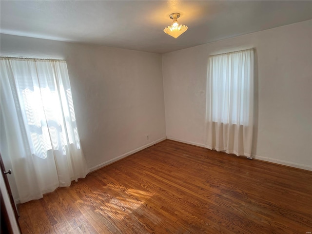 spare room featuring wood finished floors and baseboards