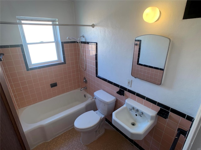 full bathroom featuring toilet, a sink, shower / bathing tub combination, tile walls, and tile patterned flooring