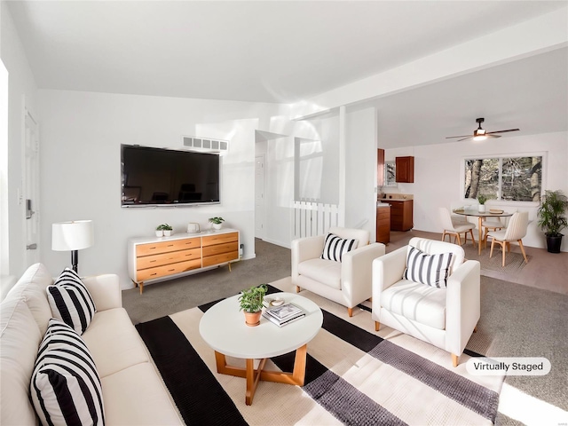 living room with visible vents, carpet floors, and ceiling fan