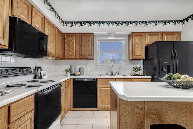 kitchen featuring light tile patterned flooring, a sink, black appliances, light countertops, and backsplash