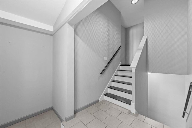 stairway with tile patterned floors and baseboards