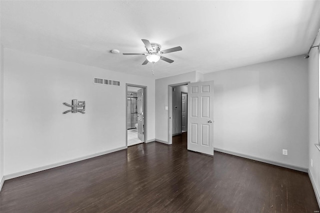 spare room featuring a ceiling fan, wood finished floors, visible vents, and baseboards