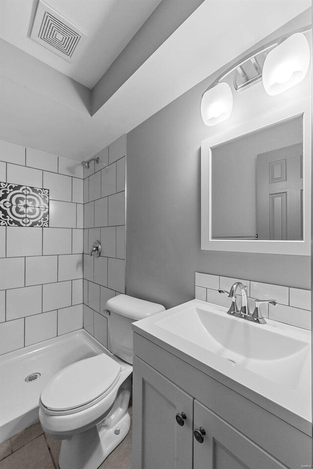 full bathroom featuring visible vents, a shower stall, toilet, and vanity