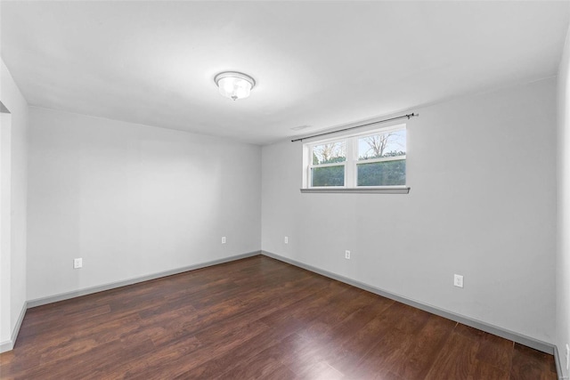 empty room featuring baseboards and wood finished floors