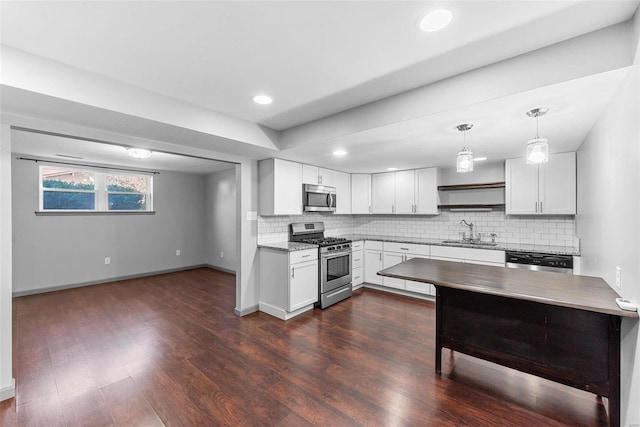 kitchen featuring a sink, stainless steel appliances, dark wood finished floors, and decorative backsplash