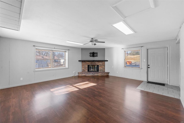 unfurnished living room with wood finished floors, a fireplace, and ceiling fan