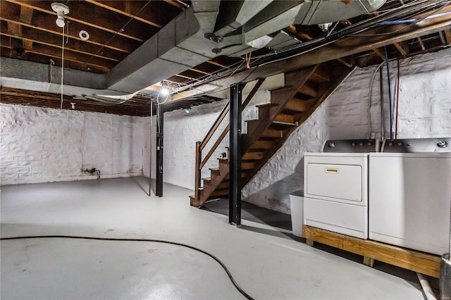 unfinished basement featuring stairs and separate washer and dryer