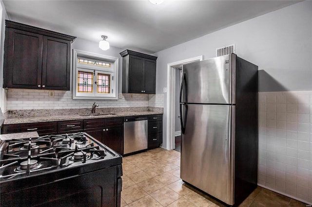 kitchen featuring light stone counters, visible vents, stainless steel appliances, and light tile patterned flooring