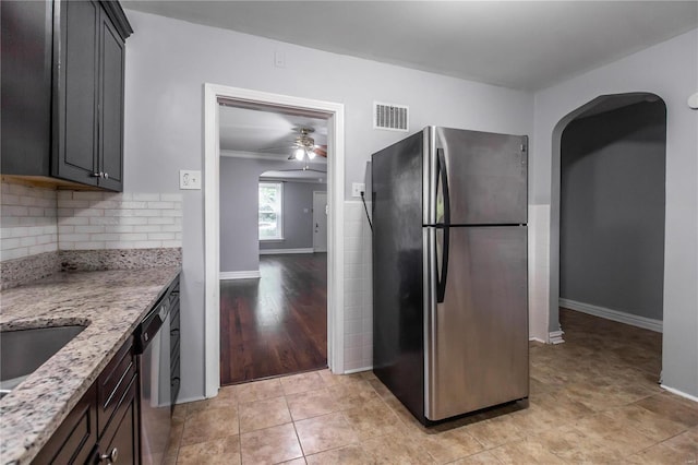 kitchen featuring a ceiling fan, light stone countertops, visible vents, stainless steel appliances, and tasteful backsplash