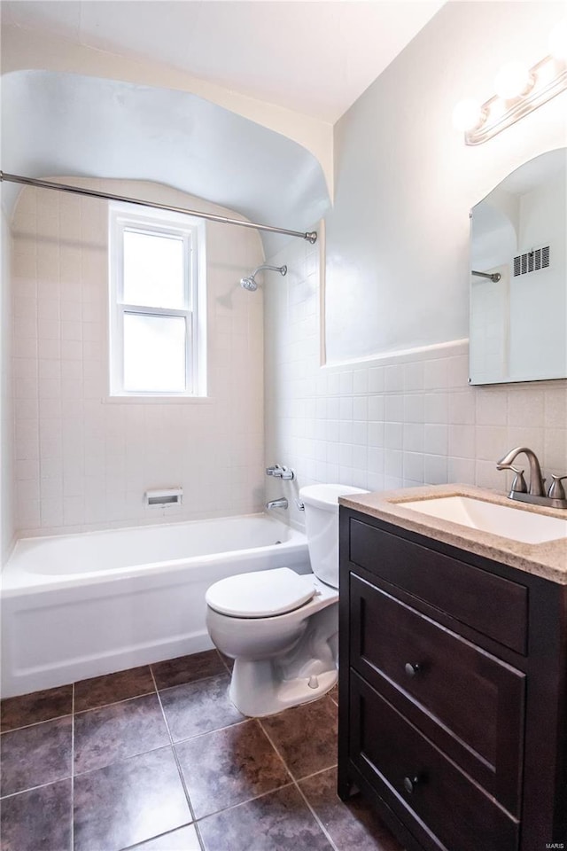 bathroom with vanity, visible vents, shower / bath combination, tile walls, and toilet