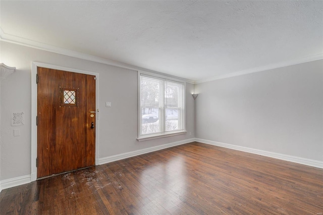 foyer featuring hardwood / wood-style flooring, crown molding, and baseboards