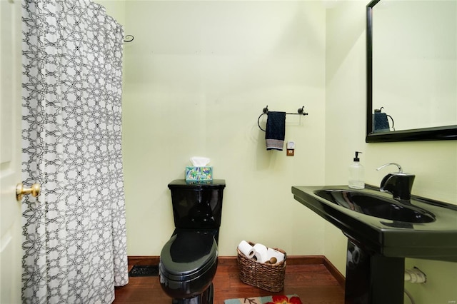 full bath with baseboards, a shower with curtain, and wood finished floors