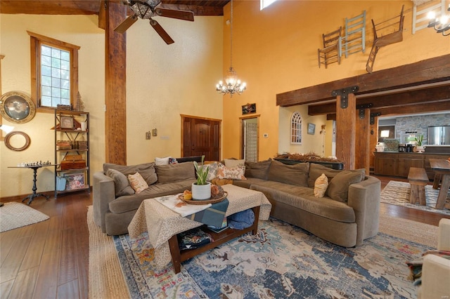 living area with a high ceiling, wood finished floors, and ceiling fan with notable chandelier