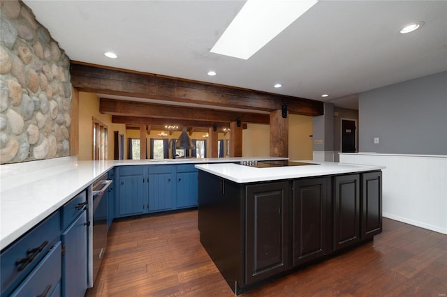 kitchen featuring blue cabinetry, a skylight, dark wood-style flooring, light countertops, and dishwasher