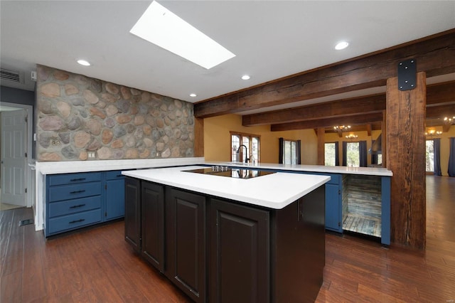 kitchen with blue cabinetry, visible vents, dark wood finished floors, and light countertops