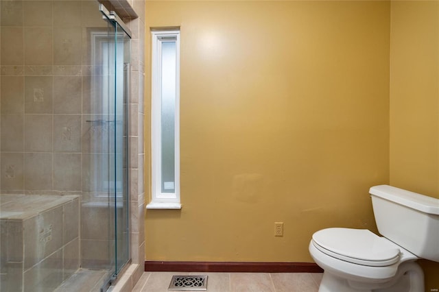 bathroom with visible vents, toilet, a shower stall, tile patterned flooring, and baseboards