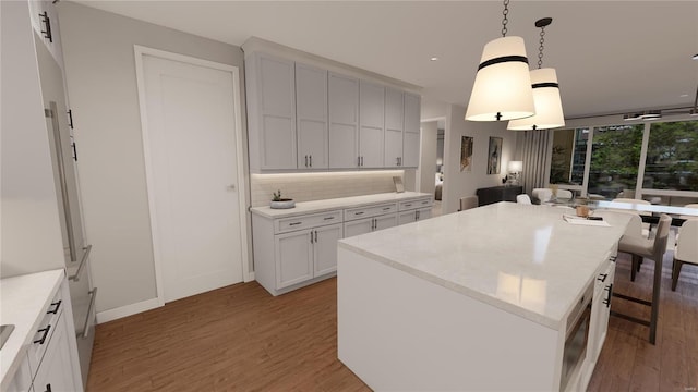 kitchen with light wood-style flooring, hanging light fixtures, a kitchen breakfast bar, backsplash, and a center island